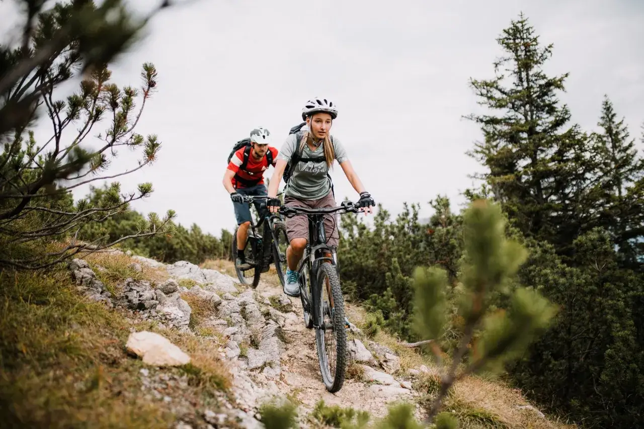 Zwei Mountainbiker auf einer steinigen Strecke, genießen die atemberaubende Landschaft bei ihren MTB Touren Garmisch.