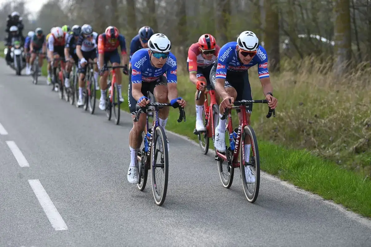 Radfahrer des Teams Alpecin-Deceuninck in blauen Trikots auf der Straße, kämpfen um die Führung.