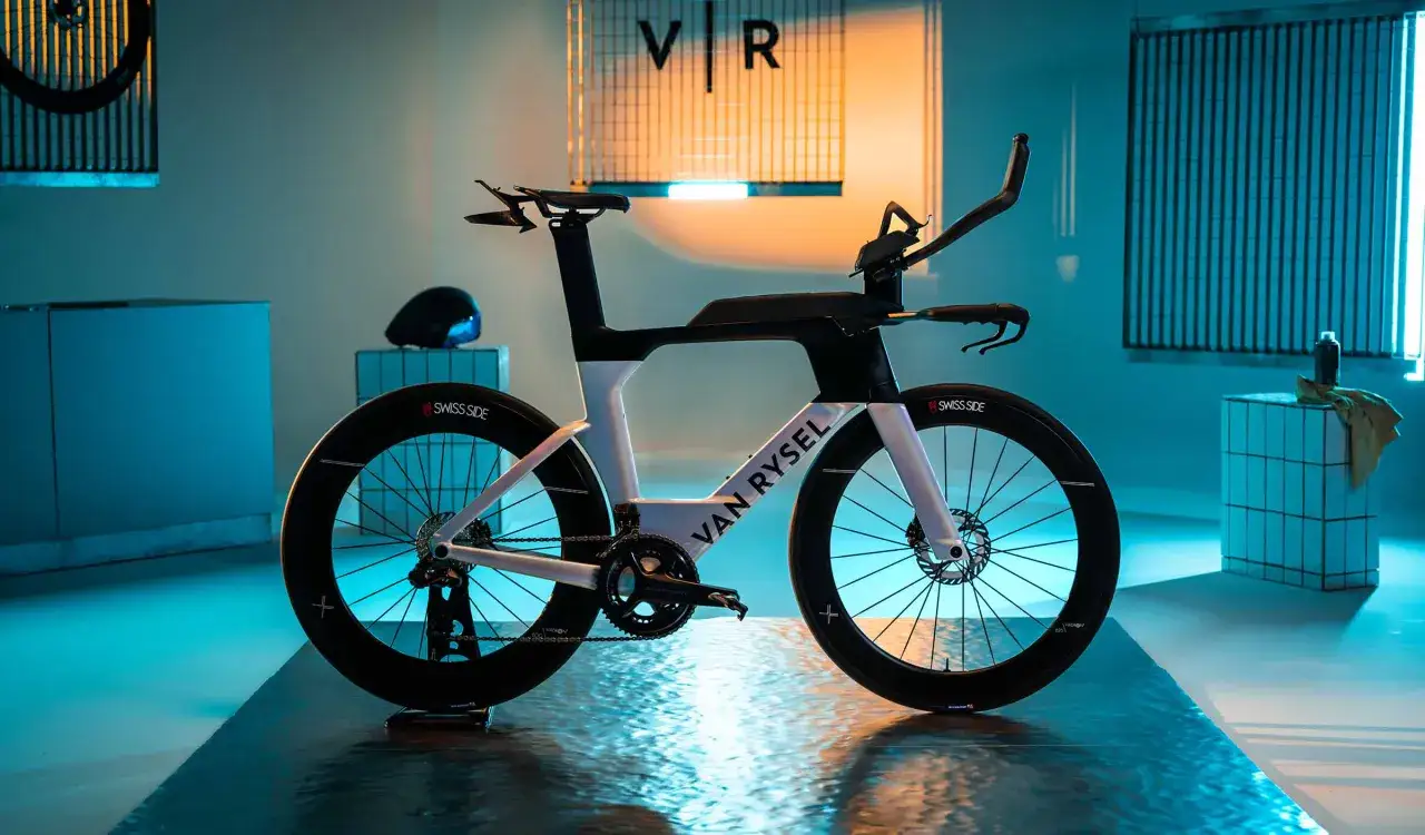 Ein aerodynamisches Van Rysel XCR Triathlonrad steht im Scheinwerferlicht.