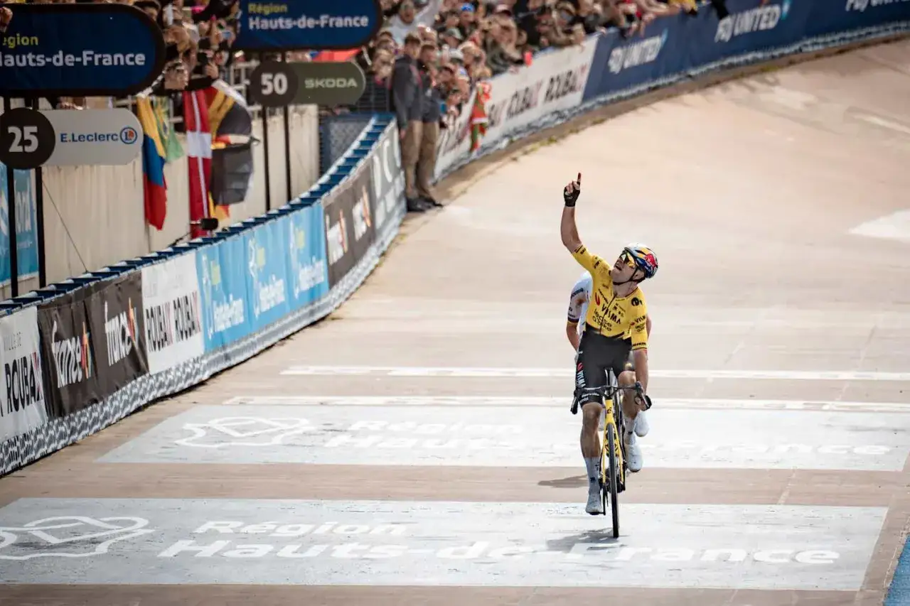 Tim Merlier jubelt nach seinem Sieg, die Hand zum Himmel gestreckt. Gelbes Trikot, Radsport-Emotionen pur.