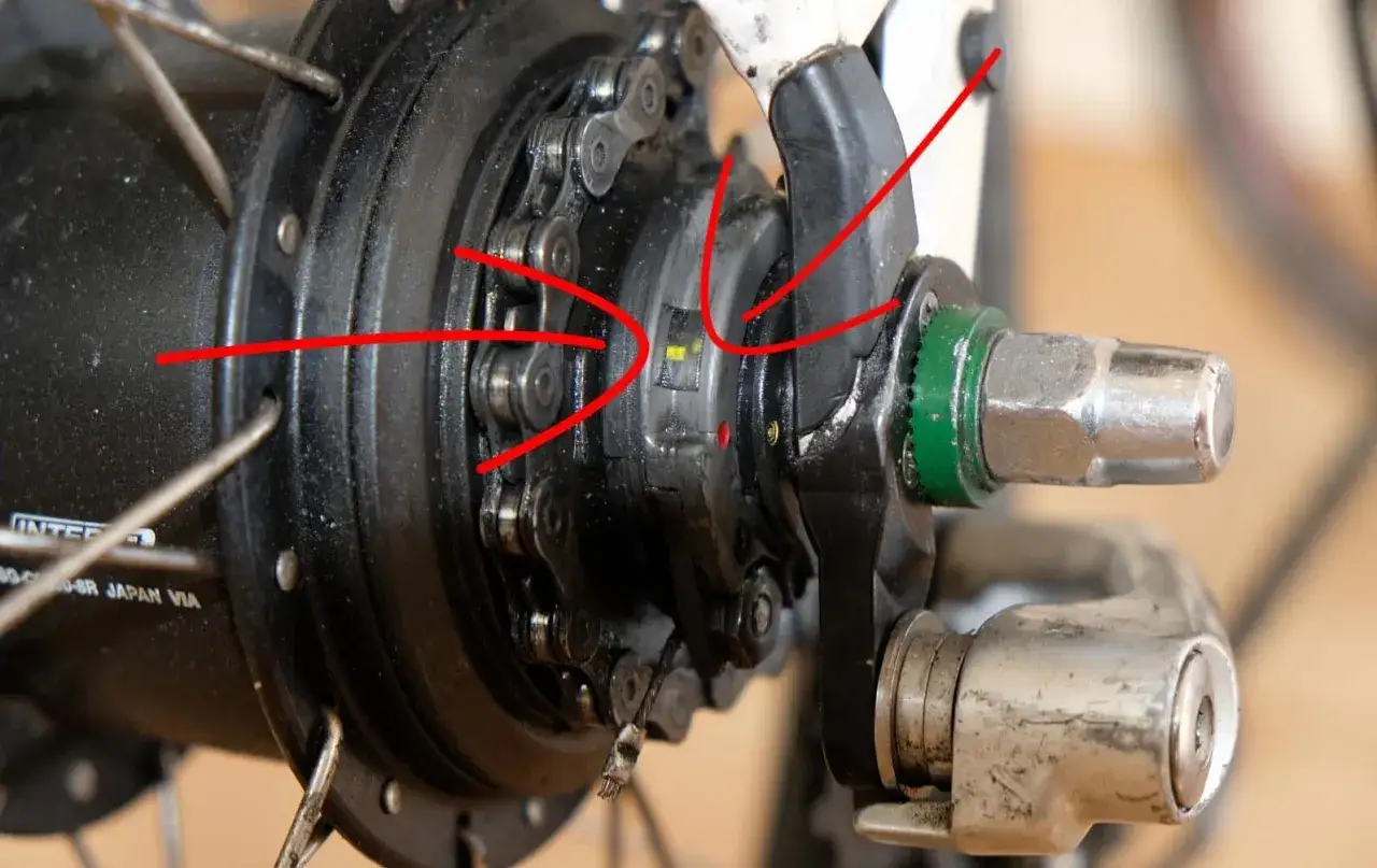 Detailaufnahme der Shimano Nexus 8 Nabenschaltung. Rote Pfeile zeigen auf die Markierungen, die zum shimano nexus 8 einstellen ben&ouml;tigt werden.