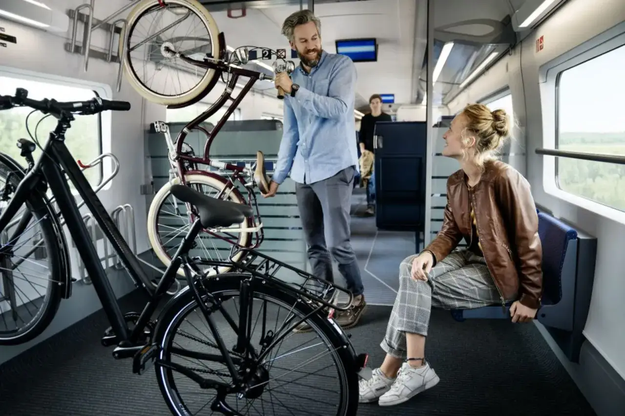 Mann verstaut Fahrrad im Zug. Gute Fahrradmitnahme ICE Erfahrungen machen, wenn man entspannt reist.