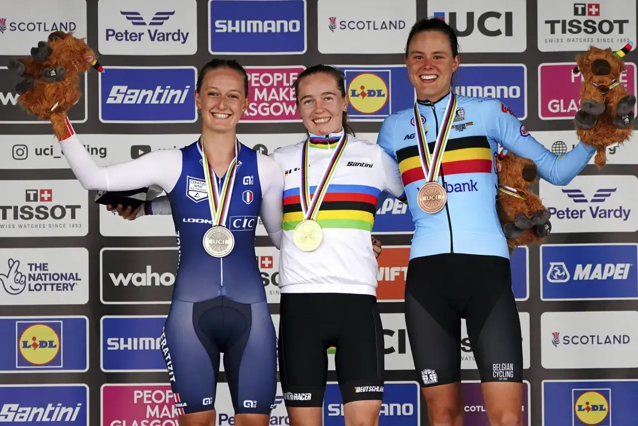 Antonia Niedermaier feiert ihren Sieg mit Medaille und Stofftier. Sie steht auf dem Podium neben ihren Konkurrentinnen.