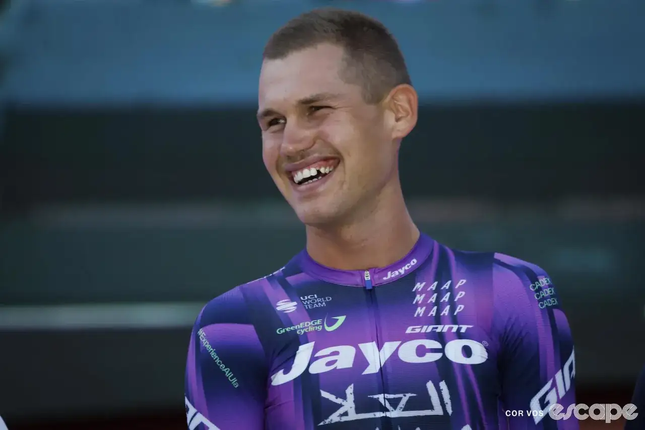 Luke Plapp lacht in seinem lila Jayco-Radtrikot.