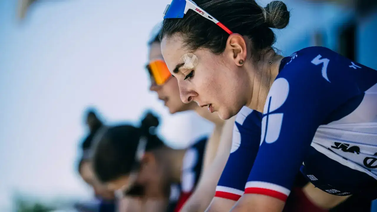 Juliette Labous, mit Pflaster auf der Stirn, konzentriert sich vor dem Rennen. Ihre Teamkolleginnen sind im Hintergrund zu sehen.