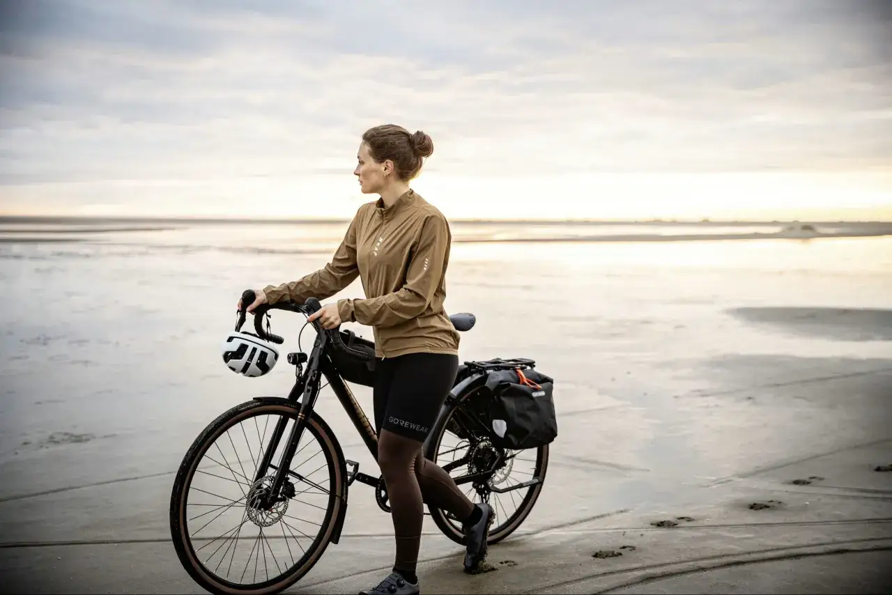 Frau mit Fahrrad am Strand, bereit f&uuml;r einen Abenteuer-Test. Der Diamant Nhoma Test ist bestanden, die Ausr&uuml;stung ist perfekt.