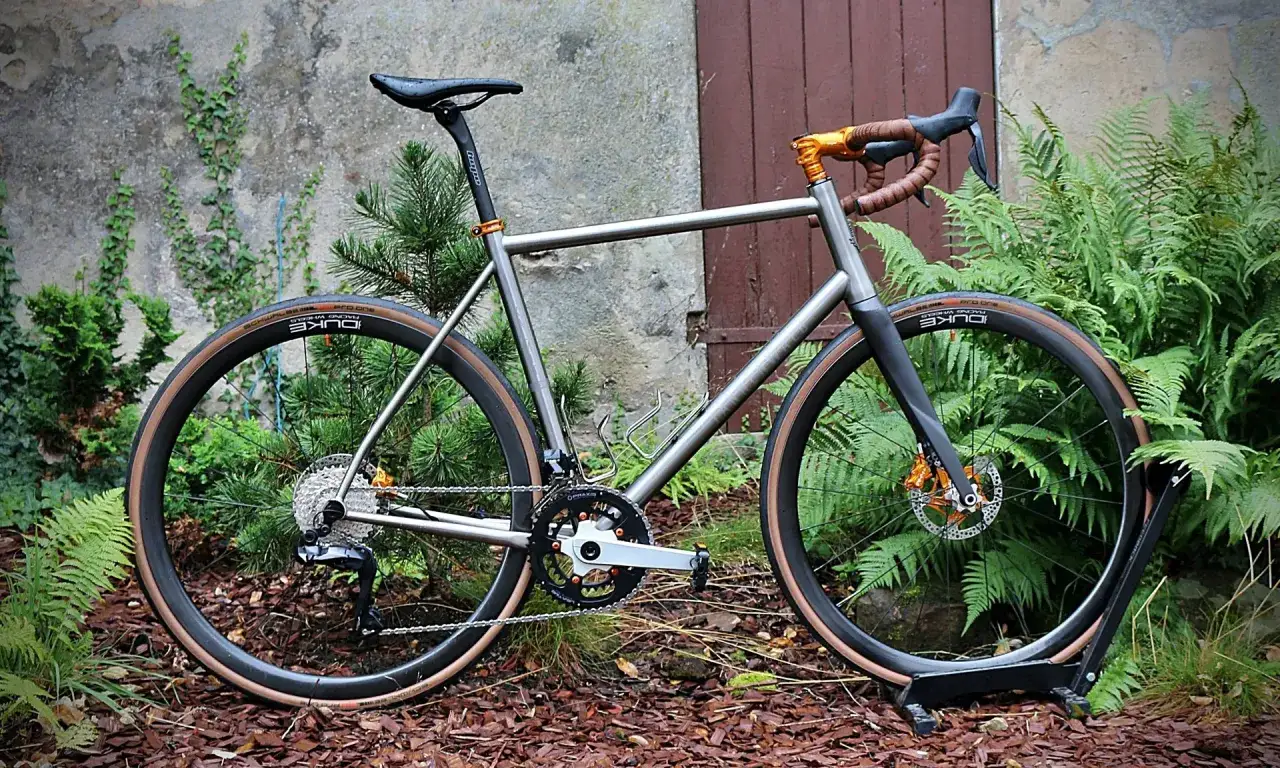 Ein Gravelbike, bereit für Abenteuer im Tannenwald. Die Reifen sind für den Einsatz auf verschiedenen Untergründen ausgelegt.