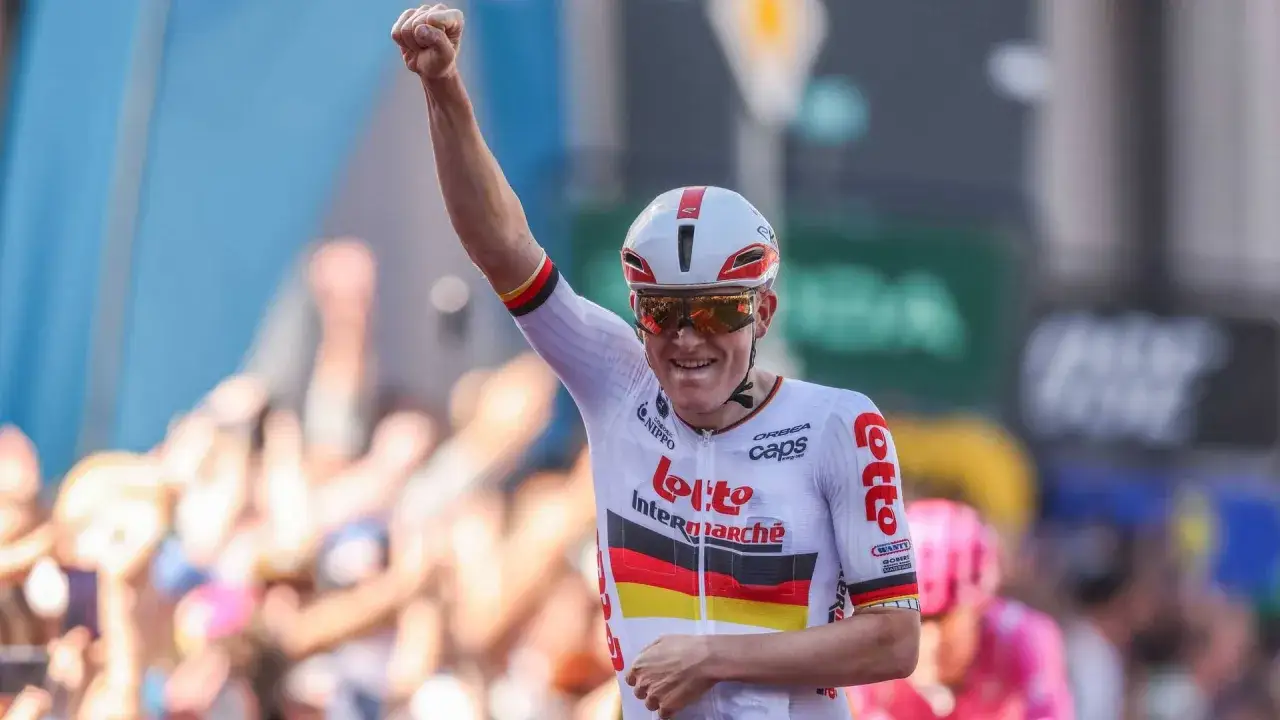 Georg Zimmermann jubelt mit geballter Faust, ein Radsportler im Deutschland-Trikot, umjubelt von Fans.