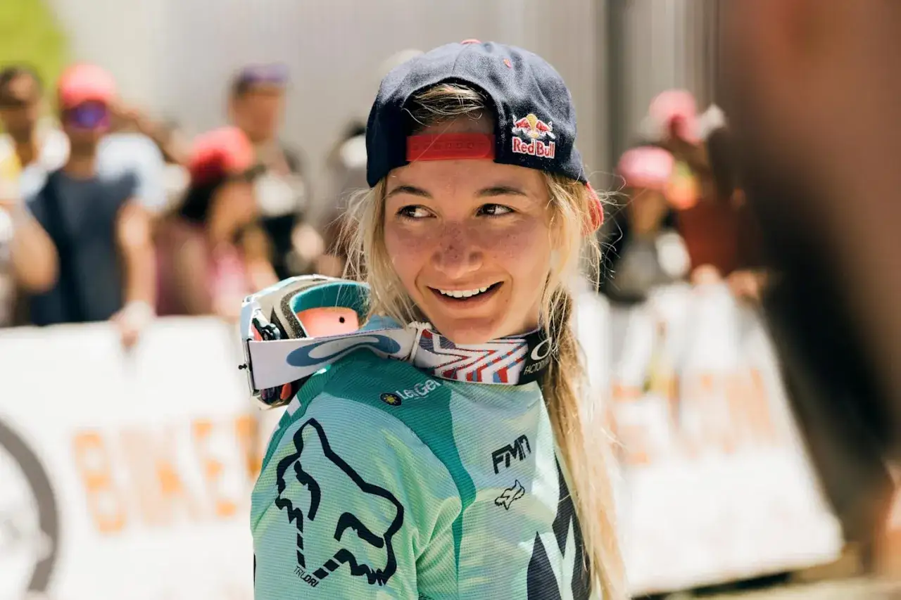 Tahnee Seagrave, lachend und mit Red Bull Kappe, bereit für das nächste Downhill-Rennen.