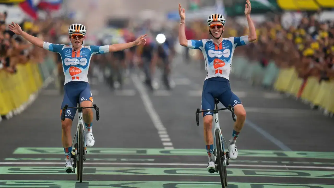 Zwei Radfahrer jubeln über die Ziellinie. Der eine, Romain Bardet, hebt die Arme triumphierend.
