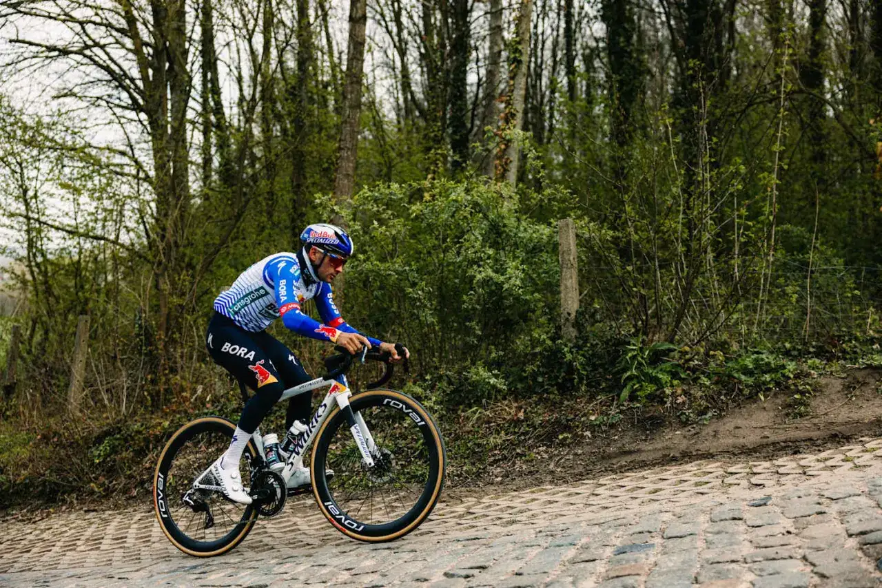 Radsportler kämpft sich auf Kopfsteinpflaster durch die Flandern Rundfahrt.