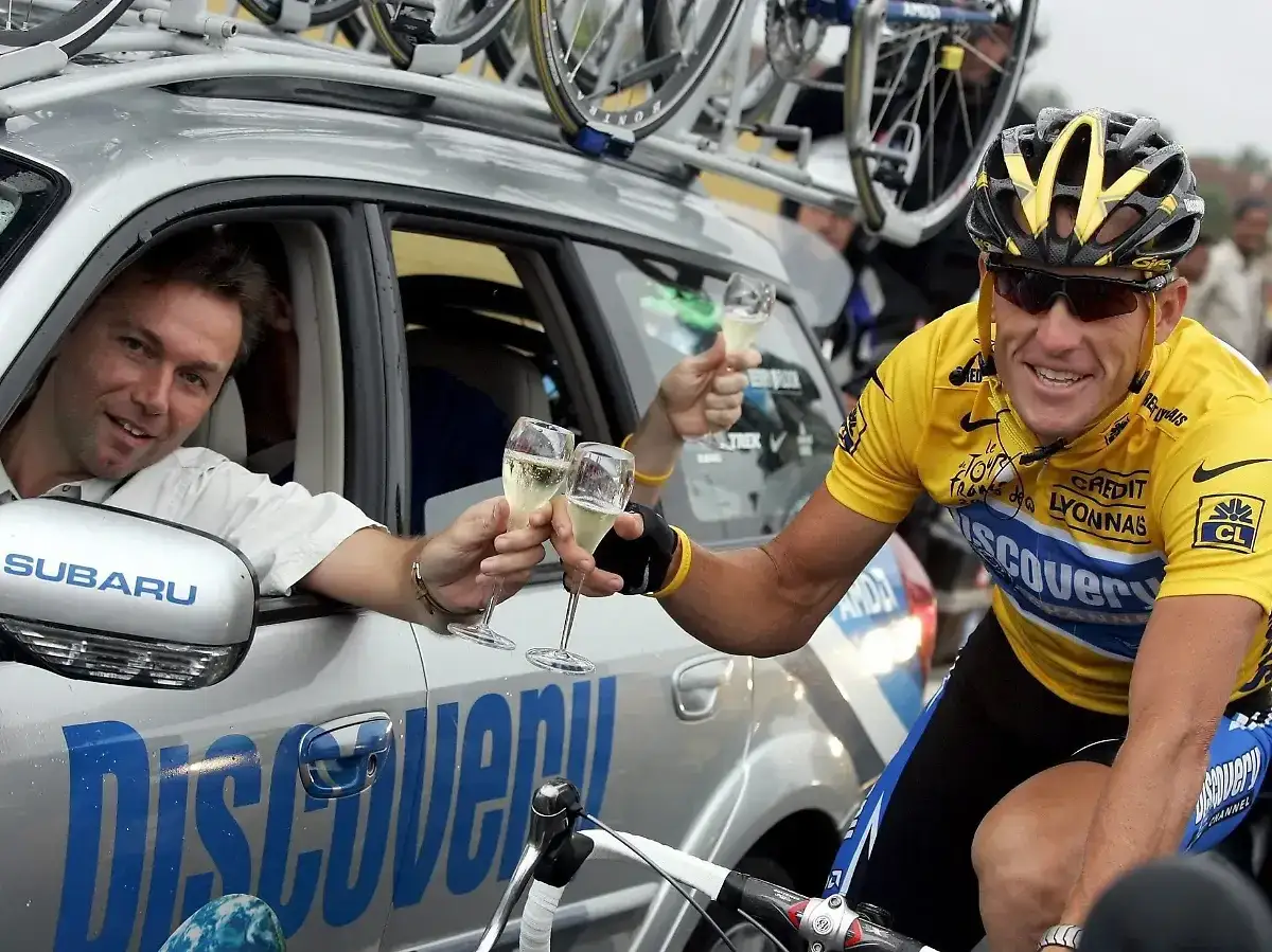 Lance Armstrong feiert mit Champagner, ein Moment der Freude, der später von Dopingvorwürfen überschattet wurde.