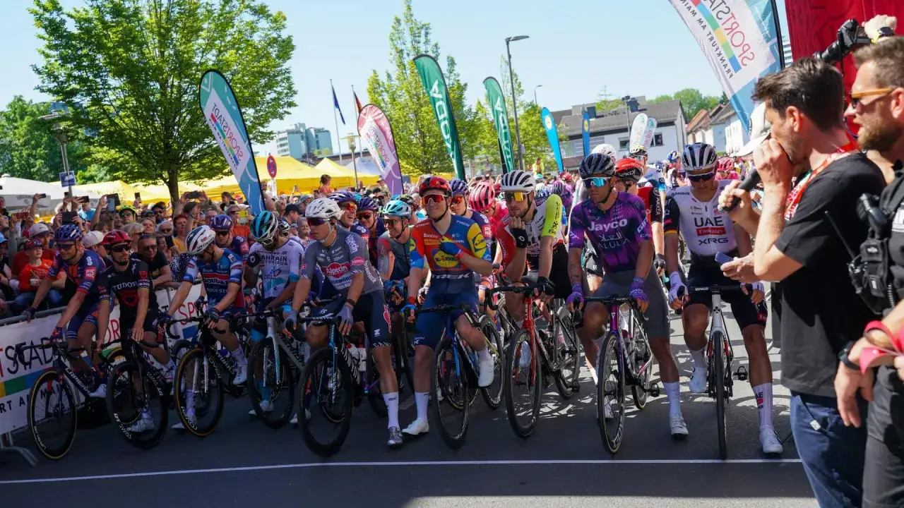 Radrennen Frankfurt: Radprofis in voller Montur am Start, jubelnde Menge im Hintergrund.