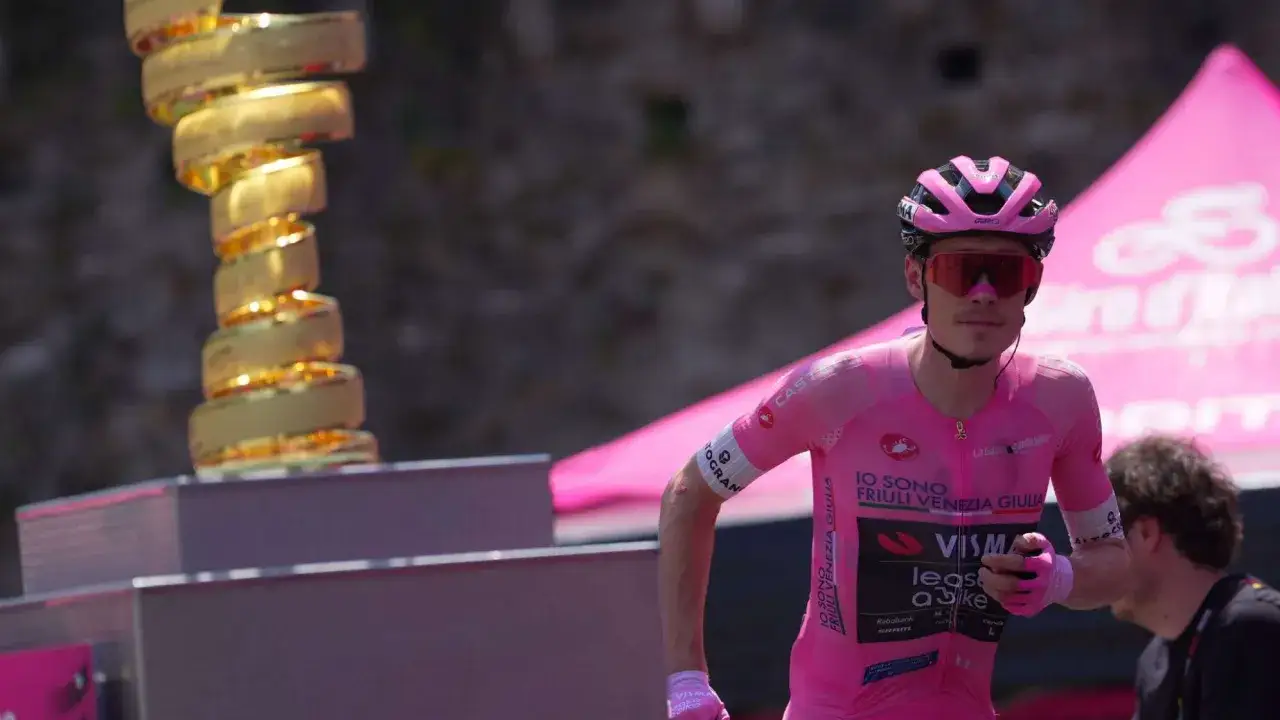 Jonas Vingegaard, jung und siegesgewiss, im rosa Trikot neben dem Giro-Pokal. Sein Alter spielt keine Rolle, wenn er so strahlt.
