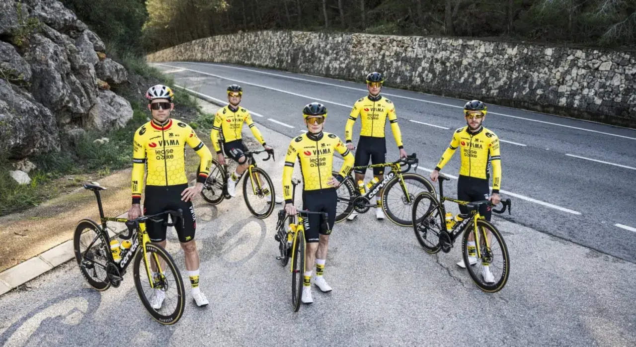 Matthew Brennan und sein Team in gelben Trikots mit Fahrrädern auf einer Bergstraße.