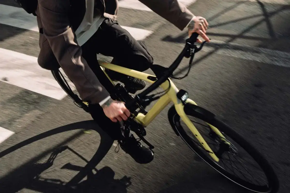 Mann fährt mit einem gelben Rose Sneak Plus Fahrrad über eine Zebrastreifen.