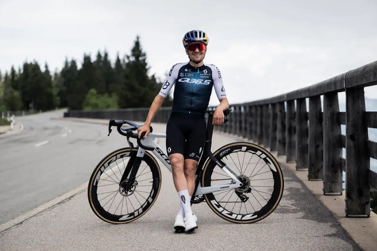 Thomas Pidcock, lächelnd neben seinem Scott Rennrad, bereit für die nächste Herausforderung.