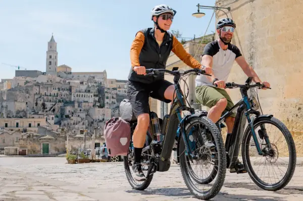 Ein Paar genießt eine Fahrt mit ihrem Buddy Bike durch eine historische Stadt.